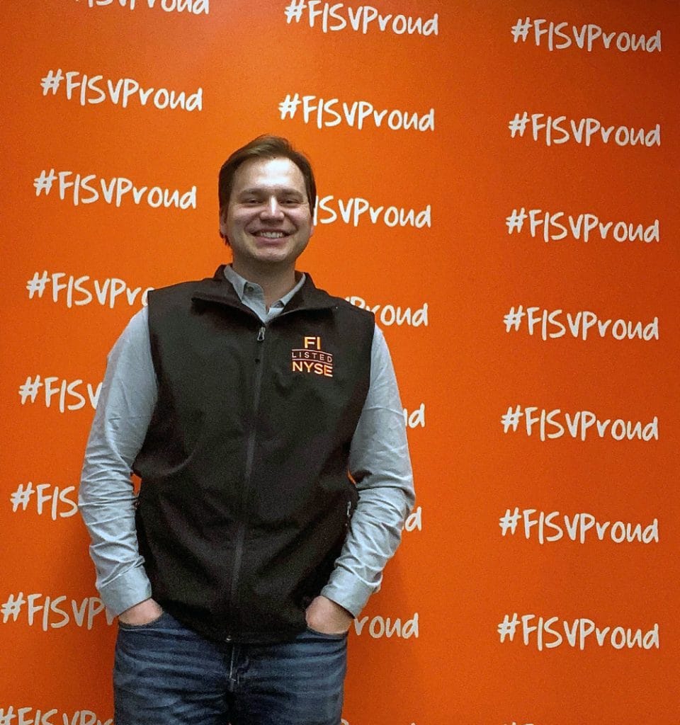 Photo of Blake Tyrell in front of a red Fiserv wall.