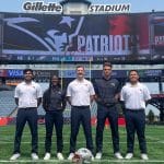 A photo of five athletic trainers on a football field.