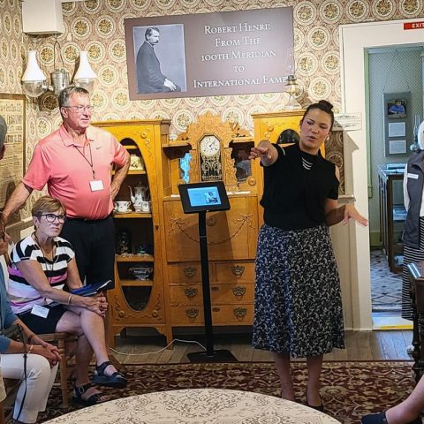 Ally Goad gives a museum tour to a busload of visitors sponsored by the State of Nebraska Historical Society Foundation.