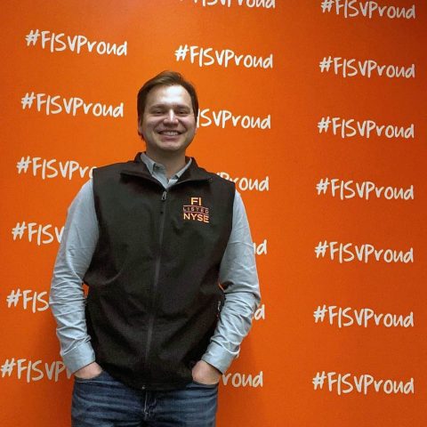 Photo of Blake Tyrell in front of a red Fiserv wall.